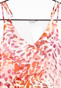 Hihaton mekko kukkakuvioilla ja V-pääntiellä. Mekossa on vaaleanpunaisen, oranssin ja punaisen sävyjä kevyessä kankaassa ja ohuet olkaimet.