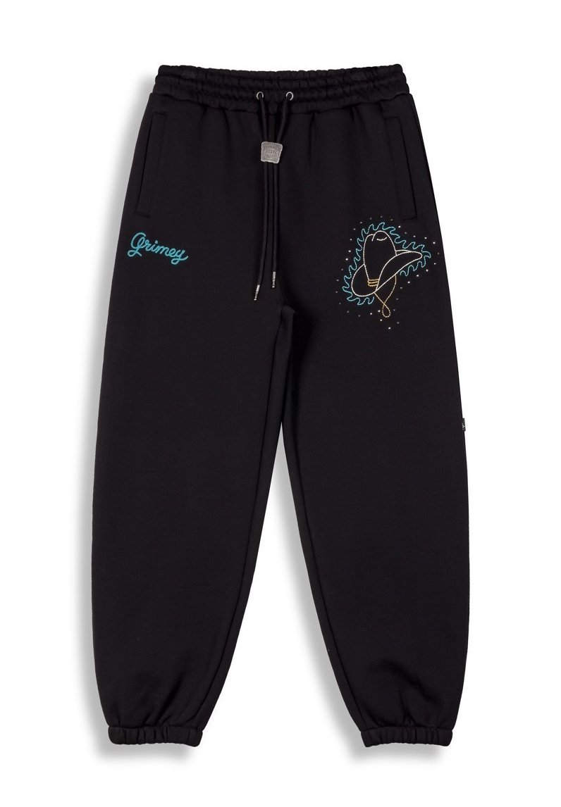 Pantalones jogger negros hechos de tela suave, con cinturilla elástica y cordón, bolsillos laterales y bordado colorido en el muslo izquierdo.