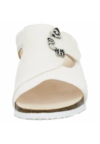 White leather sandal featuring an open toe, side cutouts, and a metallic buckle accent. The sole is textured with a white base.