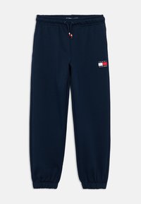 Σκούρες μπλε φόρμες φτιαγμένες από μαλακό ύφασμα, με ελαστική ζώνη μέσης και κορδόνι σύσφιξης, καθώς και ένα μικρό λογότυπο στην αριστερή μηριαία πλευρά.