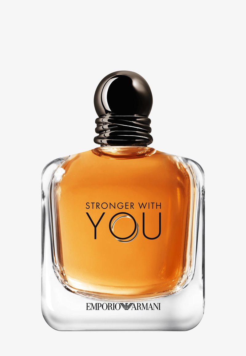 Klar glasflaska med en bärnstensfärgad vätska. Svart, ribbad kork. Etiketten läser "STARKARE MED DIG" i fet svart stil, med en cirkulär accent.