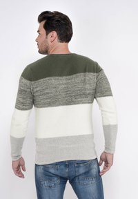 Strickpullover mit Rundhalsausschnitt, ausgestattet mit horizontalen Streifen in Dunkelgrün, Hellgrau, Creme und sanftem Grau. Textilstruktur, taillierte Form.