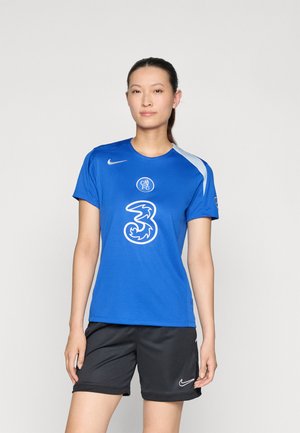 Tricou sportiv albastru cu mâneci scurte, având un logo și grafice albe pe față. Asortat cu șorturi negre, confecționate dintr-un material respirabil.