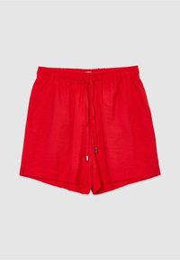 Short rouge décontracté avec taille élastique et cordon, poches latérales et petites fentes latérales sur fond gris clair.