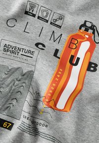 Tessuto grigio con icone di attrezzatura da arrampicata, linee di contorno della montagna, testo "Spirito d'Avventura" e un'illustrazione di una bottiglia d'acqua arancione con la parola "ARRAMPICATI".