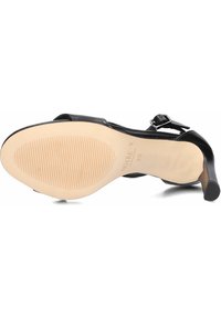 Schwarzer Leder-Highheel-Schuh mit runder Spitze, Knöchellasche und Schnallendetail. Texturierte Sohle mit Rillen für besseren Grip. Größe 38.