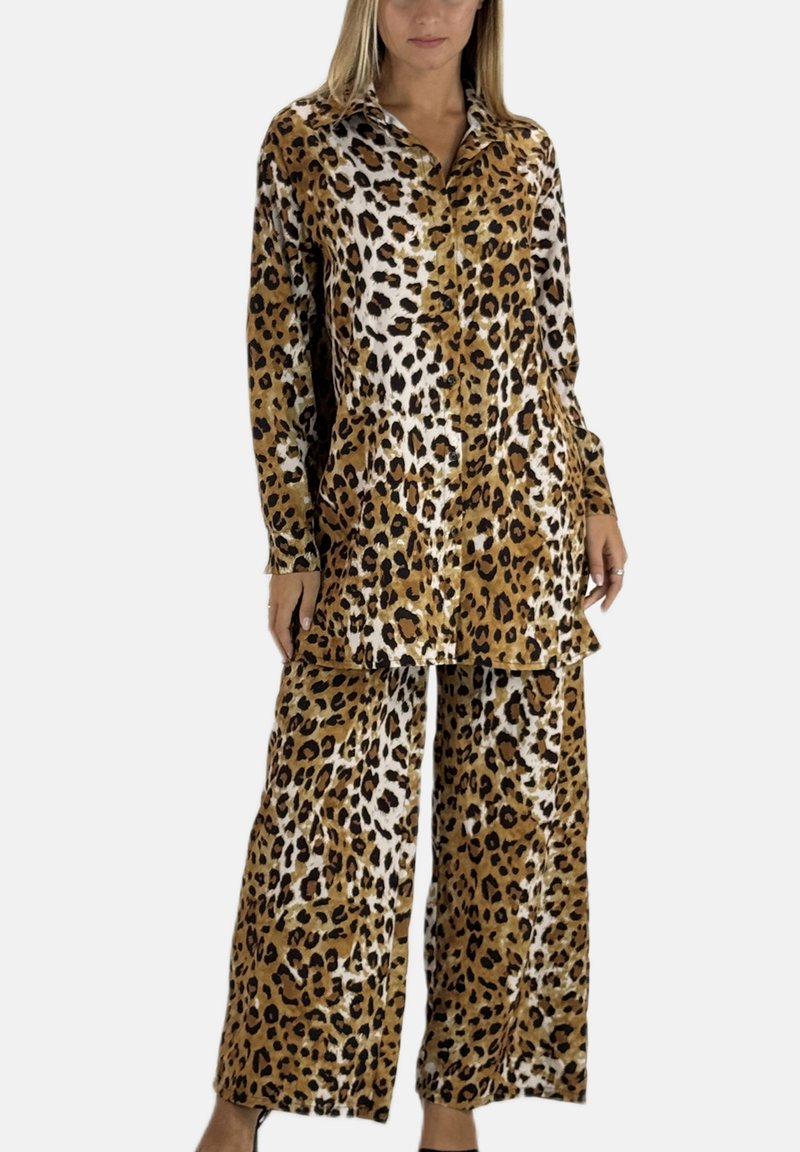 Conjunto de pijama con estampado de leopardo en marrón y crema, que incluye una camisa con botones y dos bolsillos delanteros, y pantalones de corte holgado. Textura suave.