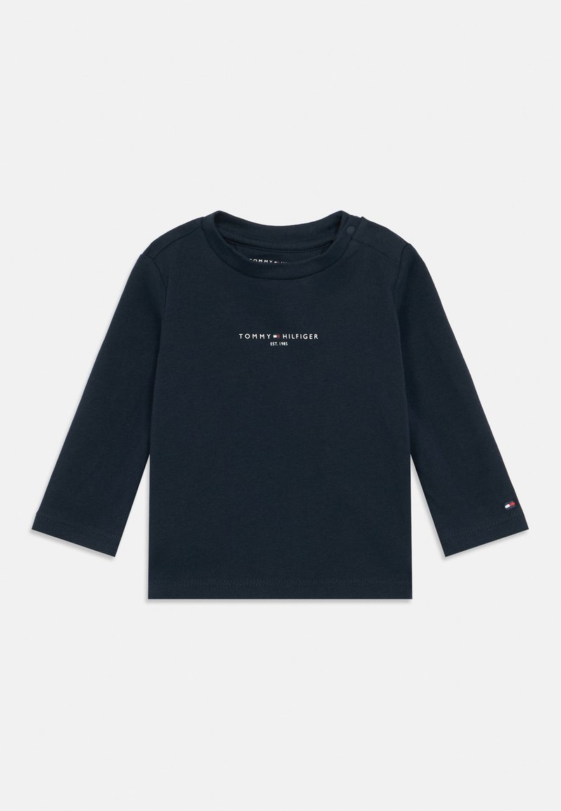 T-shirt de manga longa azul-marinho, feito de algodão, com gola redonda, apresentando uma pequena impressão de logótipo no peito e uma etiqueta com detalhes em vermelho, branco e azul.