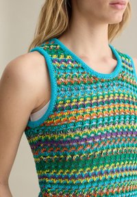 Top senza maniche lavorato a maglia in turchese, caratterizzato da motivi multicolore di fili verdi, arancioni, viola e gialli con una finitura testurizzata.