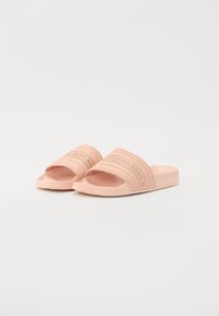 Rosa gummisklisandaler med to horisontale teksturerte stropper med preget merkenavn, åpen tå og flate såler.
