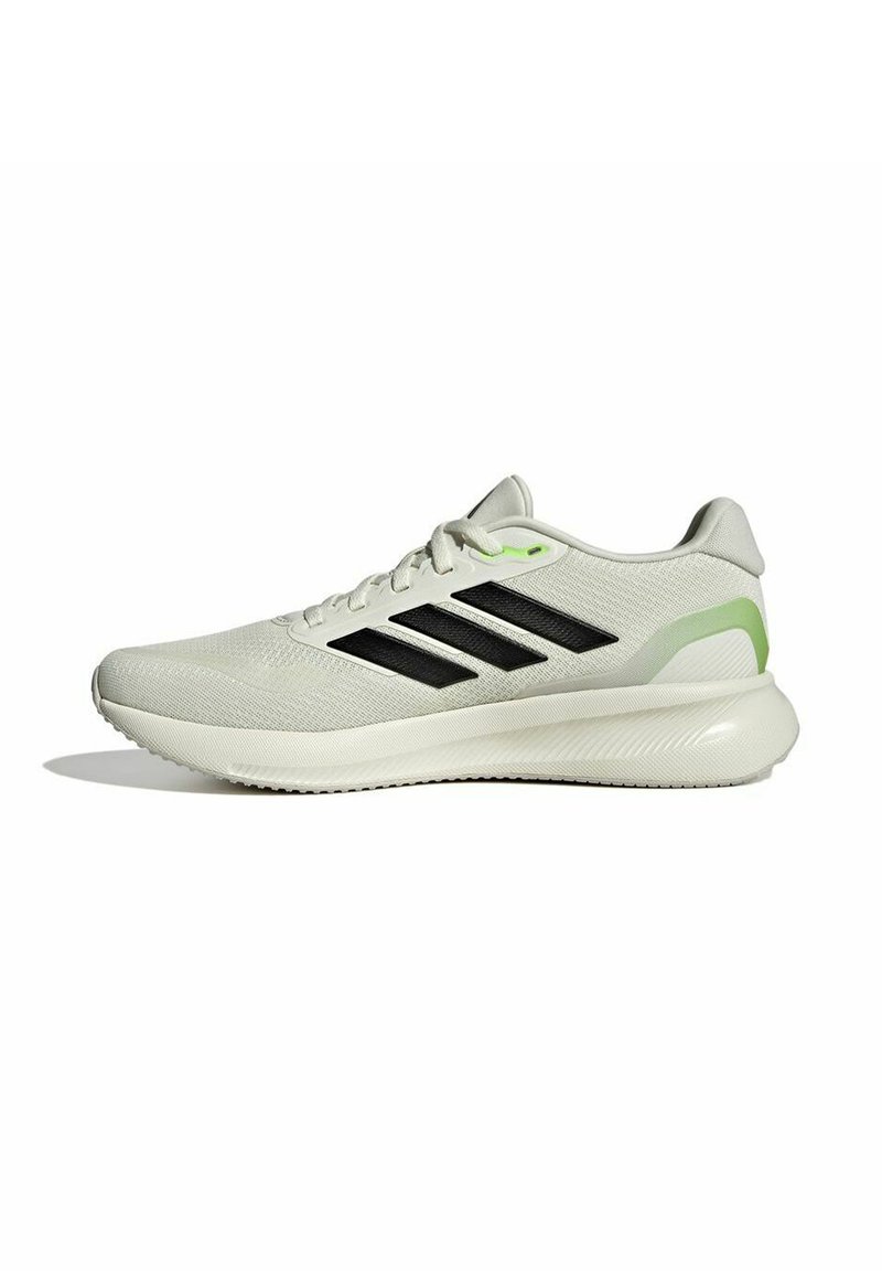Zapatilla de running para hombre con parte superior de malla gris clara, diseño de tres franjas negras, detalles en verde y suela blanca texturizada.