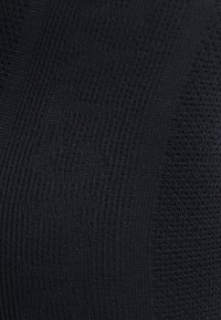 Tissu noir texturé avec une vue rapprochée montrant un mélange de motifs et de tissages, créant une apparence superposée et de la profondeur.