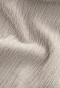 Textured fabric with fine, parallel stripes in shades of beige and cream. The surface has a soft, woven appearance with subtle depth.