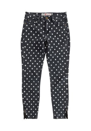 Zwarte skinny jeans met witte stippen, gulp met rits, riemlussen en ritsen bij de enkels.