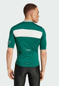 Grünes Radtrikot mit weißen horizontalen Streifen, kurzen Ärmeln und einem aerodynamischen Design. Mit AEROREADY-Label und reflektierenden Details.