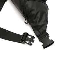 Czarna torba na ramię wykonana z fakturowanego materiału, z zamkiem błyskawicznym, regulowanym paskiem oraz plastikową klamrą zapewniającą bezpieczne zapięcie.