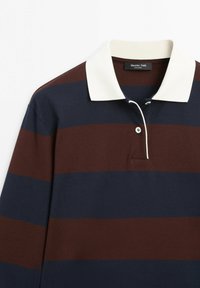 Maglia da rugby a maniche lunghe con ampie strisce orizzontali navy e marroni, colletto bianco e chiusura con due bottoni.