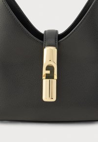 Čierna kožená kabelka s kovovým zlatým zapínaním s logom, textúrovaným povrchom a zaobleným tvarom.