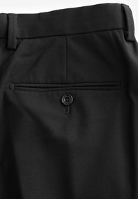 Pantalones negros con un bolsillo trasero con un solo botón negro, confeccionados en una tela texturizada, que muestra un diseño a medida.