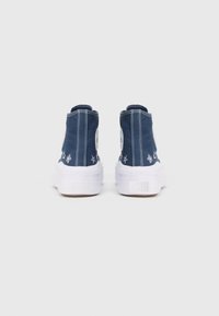 Sneaker blu alte con suole in gomma bianca, caratterizzate da un logo circolare e stelle ricamate sui lati. Materiale in tela, superficie texturizzata.