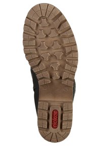 Skosula med djupt, robust mönster och röd Rieker-logotyp nära hälen, utformad för grepp och hållbarhet.