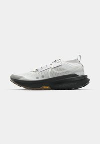 Białe buty do biegania z przewiewną siateczkową cholewką, czarną gumową podeszwą, wyraźnym amortyzacją i żółtym akcentem "Vibram" na śródpodeszwie.