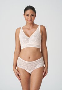 Lichtroze kanten bralette en bijpassende high-waisted slip, met ingewikkelde geometrische patronen en een zachte, textuurachtige afwerking.