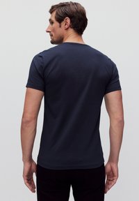 Navy-farbenes T-Shirt mit kurzen Ärmeln aus weichem Stoff, rundem Ausschnitt, figurbetontem Schnitt und glatter Textur, von hinten betrachtet.