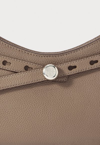 Γκρι δερμάτινη τσάντα με υφή επιφάνειας, έντονα λογότυπα με γυαλιστερό ασημένιο υλικό και κυρτό, ανοιχτό σχέδιο στην κορυφή με ραφές λεπτομέρειες.