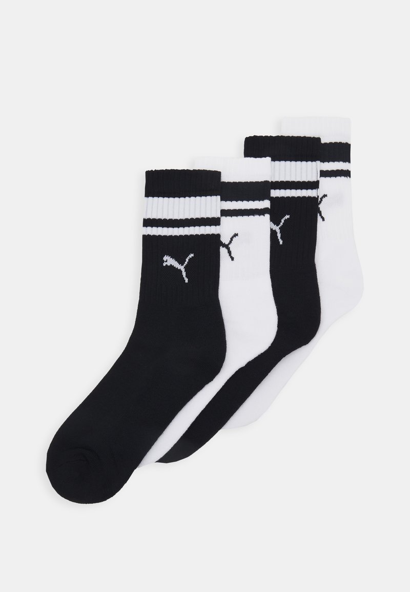 Ensemble de quatre chaussettes de sport à hauteur de cheville en noir et blanc, avec des rayures contrastées et un logo. Texture lisse, matière en mélange de coton.