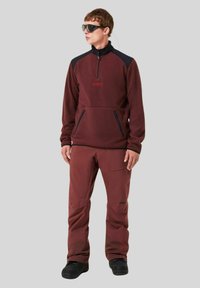 Men's maroon fleece pullover with a high collar and front zipper, paired with matching maroon pants. Includes pockets and dark accents.