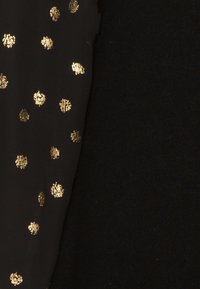 Tessuto nero con motivo a pois metallici dorati, caratterizzato da una superficie liscia e un design che combina accenti lucidi su uno sfondo opaco.