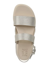 Sandalo argentato con due fasce larghe, parte superiore texturizzata e fibbia per caviglia regolabile. La suola in tonalità neutra completa il design.
