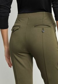 Olijfgroene op maat gemaakte broeken met een gestructureerde afwerking, voorzien van twee achterzakken met knoopsluitingen en een slim fit ontwerp.
