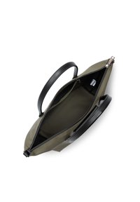 Borsa sintetica verde oliva con manici in pelle nera, chiusura con zip e un ampio interno foderato in nero che presenta una piccola tasca.