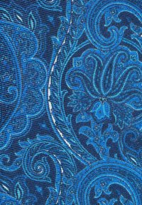 Sininen kuvioitu kangas, jossa on monimutkaisia kiehkuroita ja kukkakuvioita, tekstuuripinnalla tumman laivastonsinisen taustan päällä.