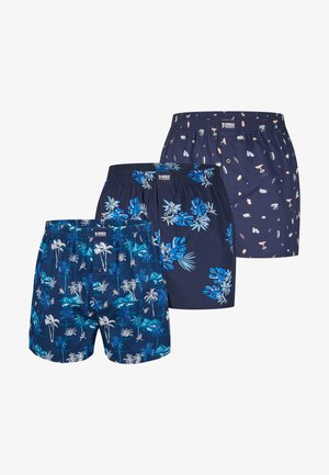 Tre par mørkeblå herreboxershorts med forskellige tropiske og abstrakte mønstre, alle med elastisk talje og knaplukning.