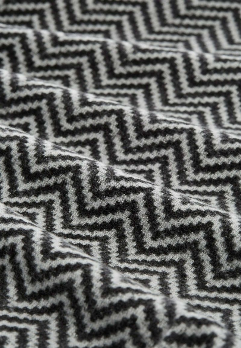 TKANA w zygzaku w odcieniach czerni i bieli, o miękkiej teksturze i geometrycznym wzorze.
