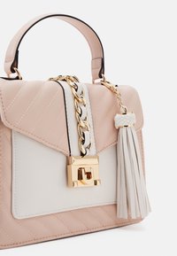 Miękka, pikowana torebka w kolorze jasnoróżowym i białym, z złotym łańcuszkiem, zamkiem na zatrzask oraz dekoracyjnym białym chwostem z boku.