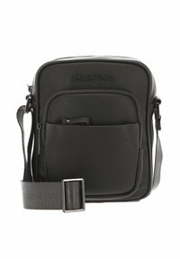 Sac bandoulière noir en matériau texturé ; il comprend une poche frontale, un logo et une sangle réglable avec une boucle en métal.