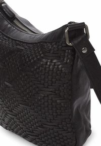 Bolso de hombro de cuero negro con textura trenzada, forma plana, herrajes de plata y correa ajustable. Cuenta con un cierre de cremallera en la parte superior.