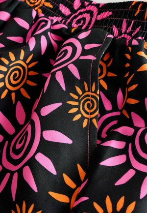 Crni materijal s živopisnim uzorcima sunca u ružičastoj i narančastoj boji. Elastični pojas s kontrastnim ružičastim šavovima i mekom teksturom.