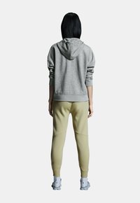 Gray hooded sweatshirt with a relaxed fit, paired with light green joggers. Both garments feature soft textures and ribbed cuffs.