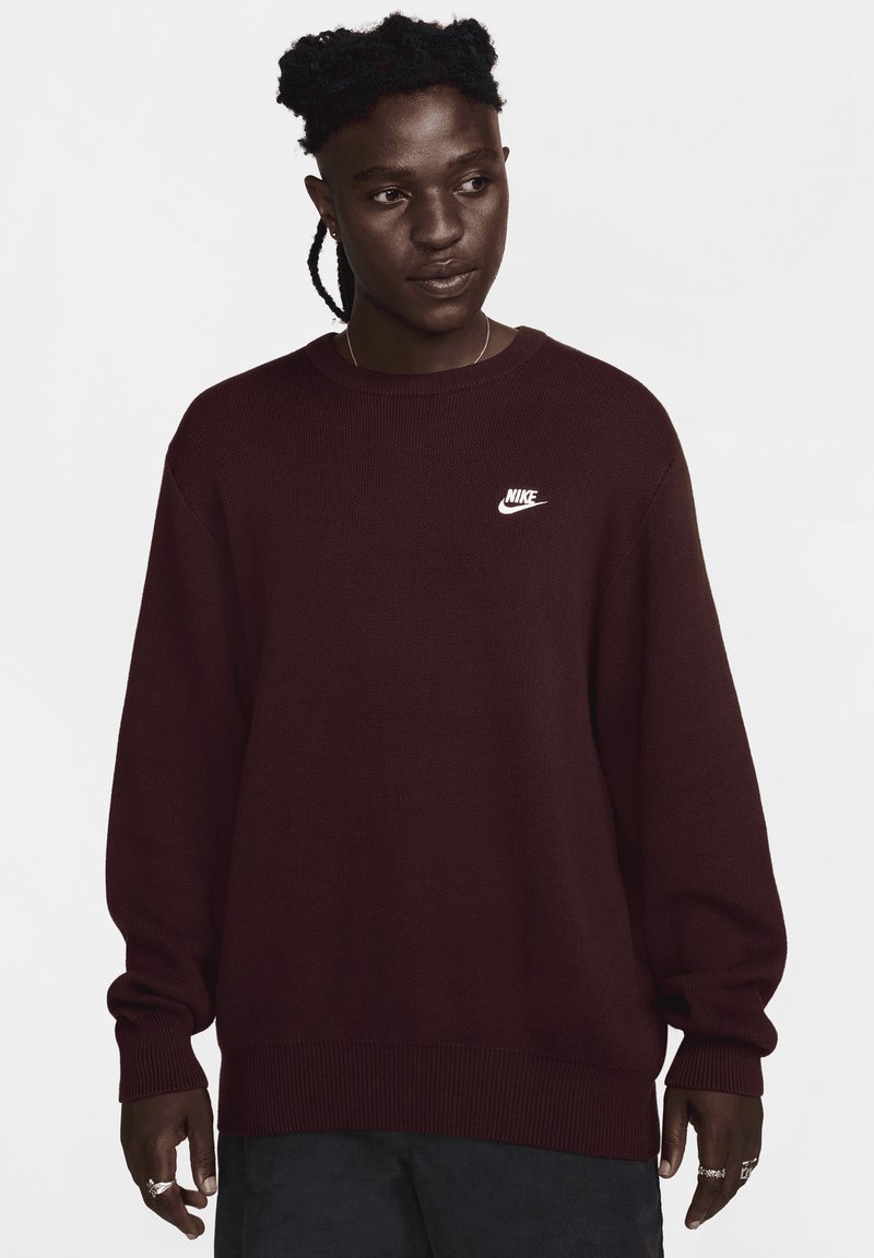 Bordeaux strikket sweatshirt med rund hals og lange ærmer. Har et hvidt Nike-logo på brystet. Blød tekstur og afslappet pasform.