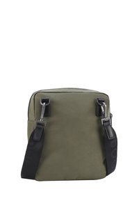 Borsa in nylon verde oliva con accenti neri, hardware argentato, tracolla regolabile e chiusura con zip. Forma quadrata con una superficie texturizzata.