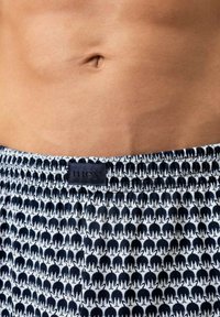 Boxershorts met een patroon van herhalende zwarte olifanten op een witte achtergrond. Elastische tailleband met een zwart logolabel.