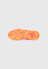 Sport shoes with a textured yellow and pink rubber sole, featuring a wavy design and cut-out sections for flexibility and grip.