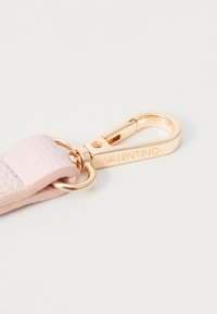 Keychain de couro rosa claro com acabamento texturizado, apresentando um fecho de metal dourado e um detalhe de logotipo gravado. Design elegante e compacto.
