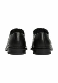 Zwarte leren dresschoenen met een gladde afwerking, ronde neus en lage hak. Voorzien van subtiele stiksels en een gecamoufleerd merklogo op de zool.