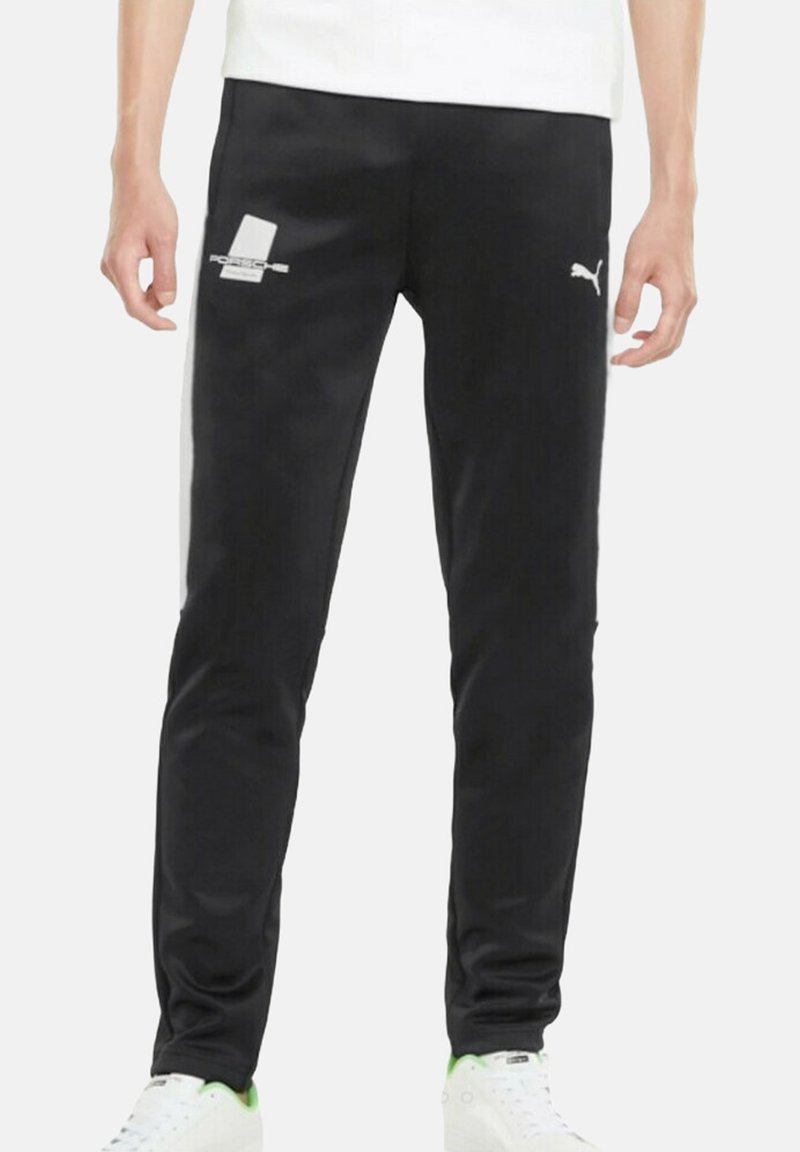 Schwarze Trainingshose mit schmaler Passform. Aus glattem Material gefertigt, mit weißen Akzenten und einem Logo auf dem linken Oberschenkel.
